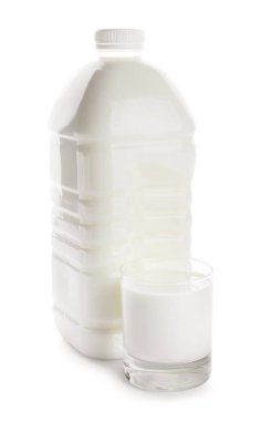 Beyaz arka planda bir şişe ve bir bardak süt.