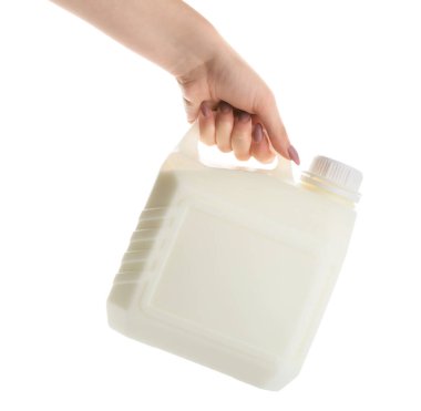 Beyaz arka planda bir şişe sütle kadın eli.