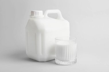 Işık arkaplanda bir şişe ve bir bardak süt.