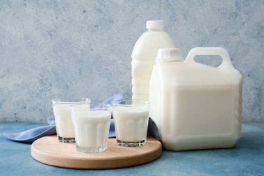 Renkli arka planda galon şişe ve süt bardakları