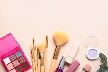 Renk arkaplanında makyaj fırçası olan dekoratif kozmetik seti