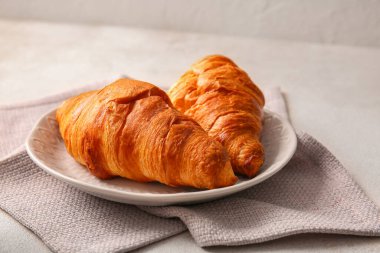 Beyaz zemin üzerine lezzetli kruvasan ile plaka