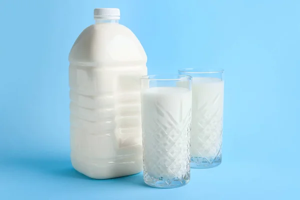 Gallonen Flasche Und Milchgläser Auf Blauem Hintergrund — Stockfoto