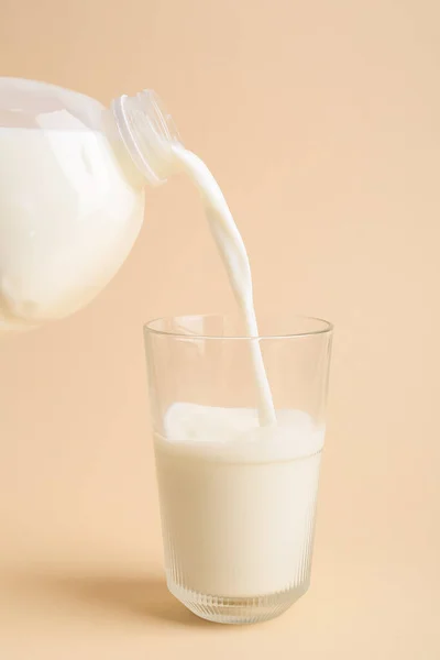 Het Gieten Van Melk Uit Gallon Fles Glas Kleur Achtergrond — Stockfoto