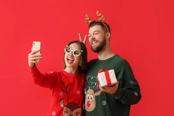 Ευτυχισμένο Νεαρό Ζευγάρι Κομψά Χριστουγεννιάτικα Ρούχα Και Δώρο Λήψη Selfie — Φωτογραφία Αρχείου