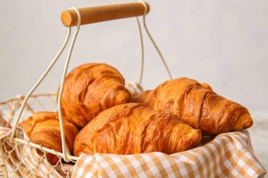 Arka planda leziz kruvasanlar olan sepet, yakın plan.