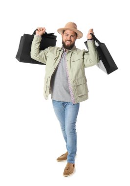 Beyaz arka planda Kara Cuma alışveriş torbaları olan yakışıklı bir adam.
