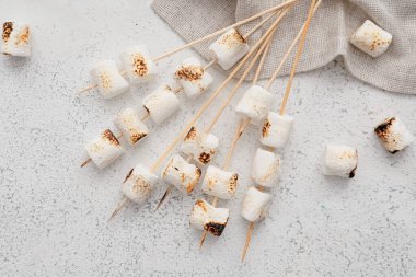 Hafif arka planda ızgara marşmelovlu şişler.