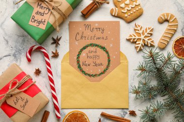 Hediyeler, kurabiyeler, mutlu noeller ve aydınlık arka planda mutlu yıllar yazılı tebrik kartı.