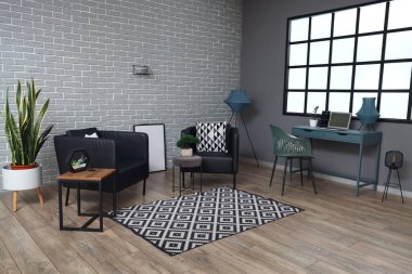 Modern koltukları ve tuğla duvarları olan şık bir oturma odası.