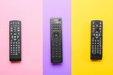 Renk arkaplanındaki farklı TV uzaktan kumandaları
