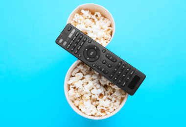 Modern TV uzaktan kumandası ve renkli patlamış mısır kovaları