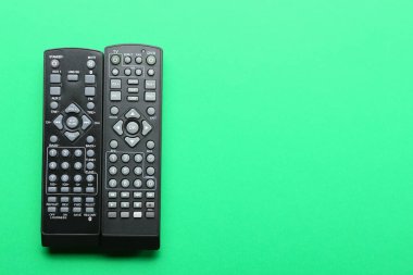 Yeşil arkaplanda modern TV uzaktan kumandaları