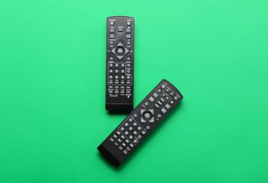 Yeşil arkaplanda modern TV uzaktan kumandaları