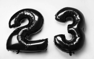 Beyaz arka planda balonlardan yapılmış 23 siyah figür.