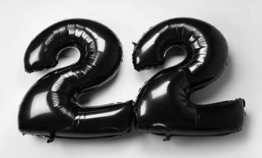 Beyaz arkaplanda balonlardan yapılmış 22 siyah figür.