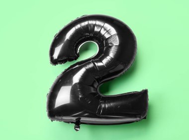 Yeşil zemin üzerinde şekil 2 siyah balon