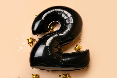 Şekil 2 şeklinde balon ve bej arkaplanda konfeti