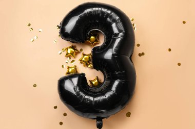 Şekil 3 şeklinde balon ve bej arkaplanda konfeti