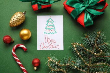 Yeşil arka planda Merry Christmas, hediye kutuları ve dekor içeren tebrik kartı