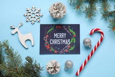 Renkli arkaplanda Merry Noelleri, dekor ve köknar ağacı dalları içeren tebrik kartı