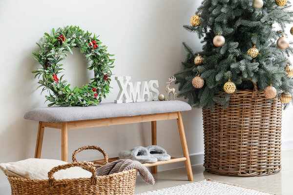 Beautiful mistletoe wreath with Christmas tree bench in interior of room