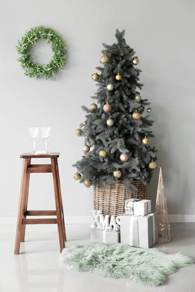 Beautiful Christmas tree with gifts and decor in interior of room