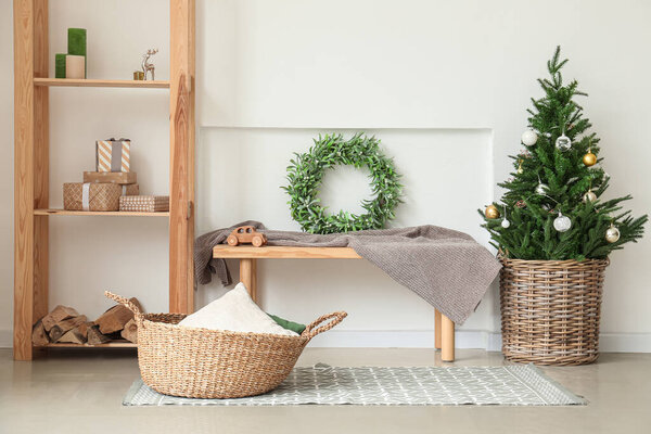 Beautiful Christmas tree with mistletoe wreath in interior of room