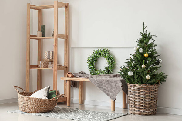 Beautiful Christmas tree with mistletoe wreath in interior of room