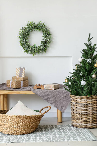 Beautiful mistletoe wreath and Christmas gifts on bench in interior of room