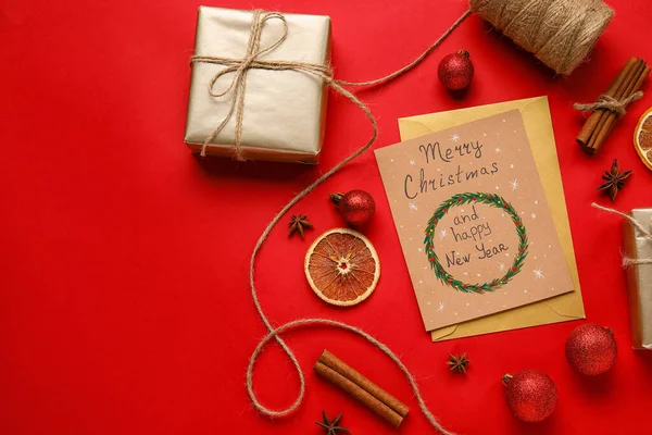 ギフト テキスト付きグリーティングカードメリー クリスマスとハッピー ニューイヤー赤を背景に — ストック写真