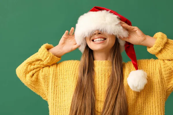 Yeşil Arka Planda Noel Baba Şapkalı Güzel Bir Kadın — Stok fotoğraf