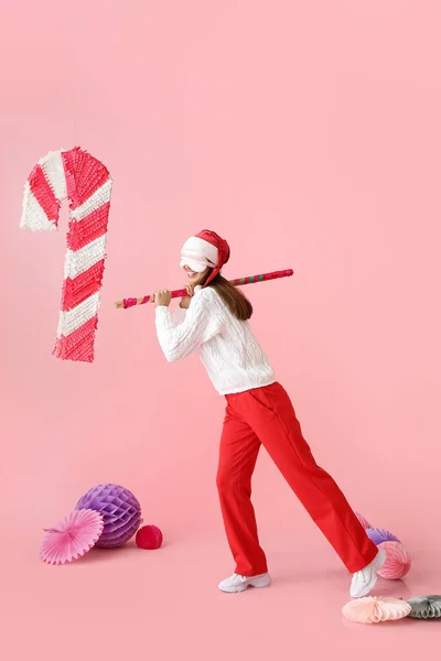 漂亮的女人戴着圣诞礼帽 头戴彩色背景的糖果皮纳塔 — 图库照片