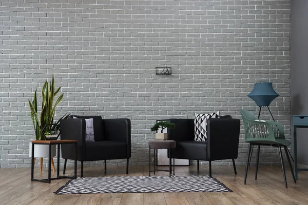 有现代扶手椅和砖墙的时髦客厅的内部 — 图库照片