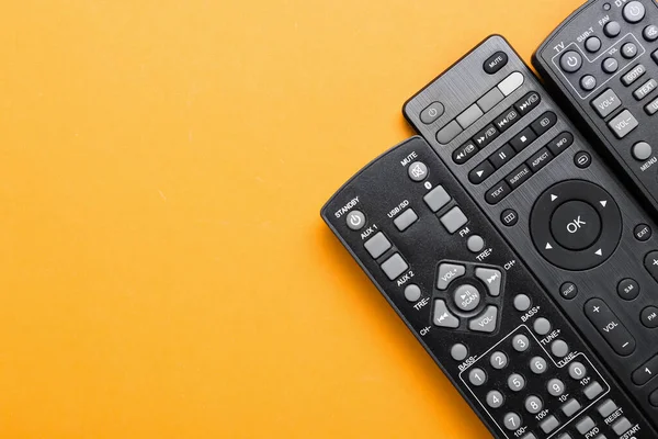 Different Remote Controllers Orange Background — Stock Photo, Image