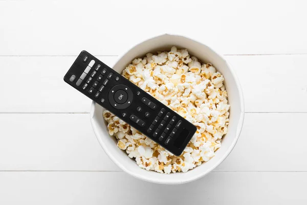 Moderne Fernbedienung Und Eimer Mit Popcorn Auf Hellem Holzhintergrund — Stockfoto