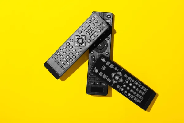 Different Black Remote Controllers Yellow Background — Stock Photo, Image