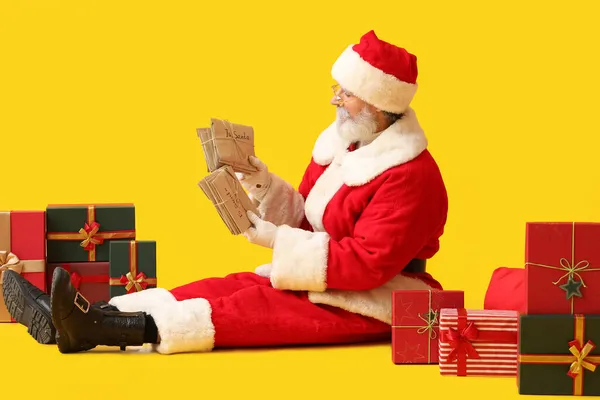 Weihnachtsmann Mit Briefen Und Geschenken Auf Gelbem Hintergrund — Stockfoto