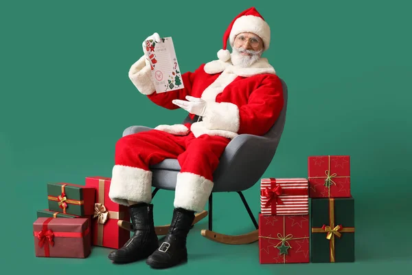Weihnachtsmann Mit Brief Und Geschenken Auf Farbigem Hintergrund — Stockfoto
