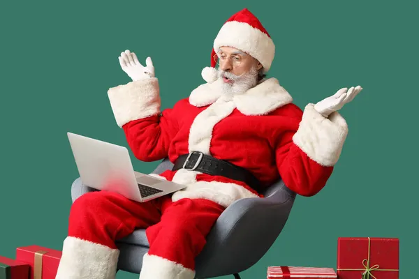 Zaskoczony Święty Mikołaj Laptopem Prezentami Tle Koloru — Zdjęcie stockowe