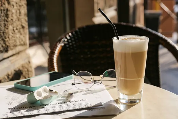 Szklanka Smacznej Kawy Słuchawki Gazeta Stole Kawiarni Świeżym Powietrzu — Zdjęcie stockowe