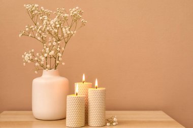 Renk duvarının yanındaki ahşap masada mum ve vazo yakıyorum.