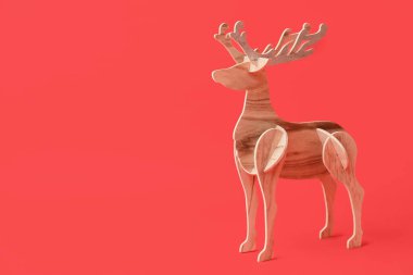 Kırmızı arkaplanda tahta ren geyiği