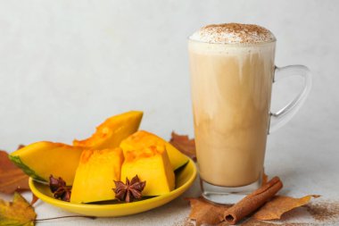 Hafif arkaplanda bir bardak lezzetli balkabaklı latte.