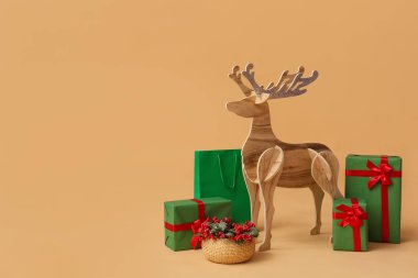 Noel hediyeli tahta ren geyiği ve bej arka planda Rowan.