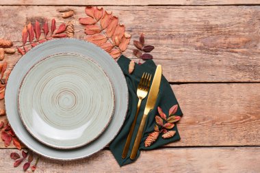 Ahşap zemin üzerinde sonbahar yaprakları ve masa düzeniyle kompozisyon