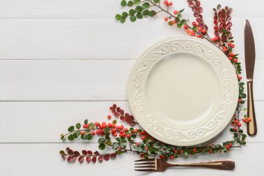 Masa düzeniyle kompozisyon ve beyaz ahşap arka planda yaban mersini.