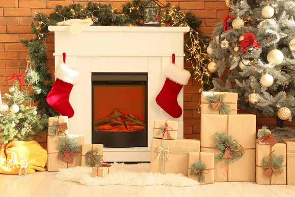 レンガの壁の近くのクリスマスソックス ギフトボックス モミの木と暖炉 — ストック写真