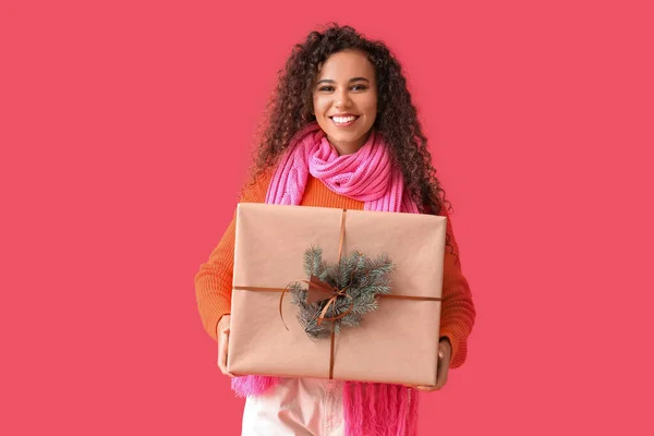 Junge Afroamerikanerin Warmem Schal Mit Weihnachtsgeschenk Auf Rotem Hintergrund — Stockfoto