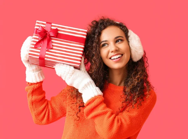 Jonge Afro Amerikaanse Vrouw Warme Oorkappen Met Kerstcadeau Rode Achtergrond — Stockfoto